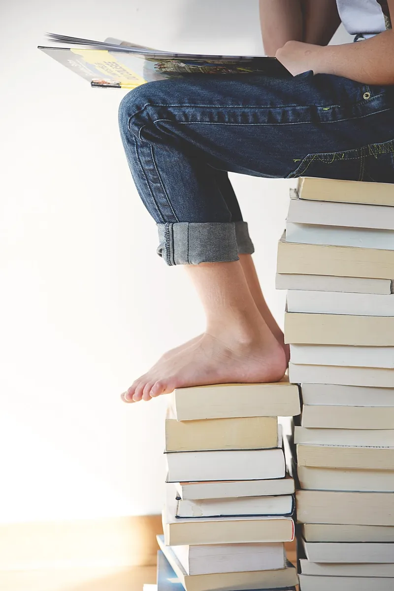 Leserin auf einem Stapel Bücher